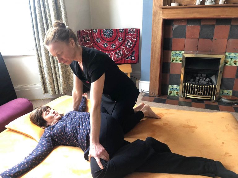 Woman giving Thai Yoga Massage on futon