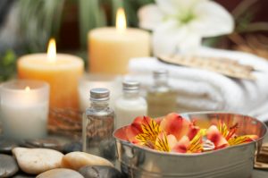An image of aromatherapy oils and candles behind them.